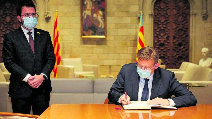 Puig firma en el libro de honor del Govern catalán ante Pere Aragonès, ayer. | INFORMACIÓN