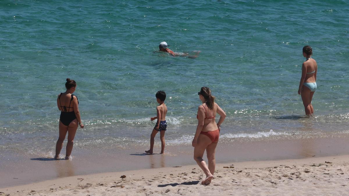 Los primeros bañitas de la temporada disfrutan de la playa Riazor con el buen tiempo