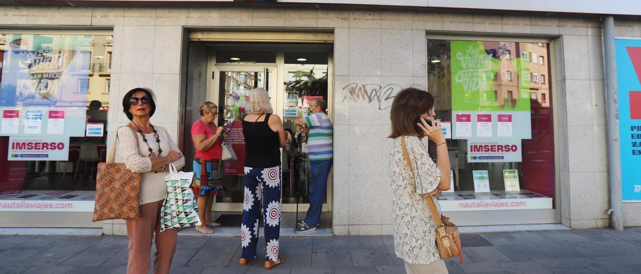 Un grupo de personas hace cola, ayer, ante la agencia de viajes Nautalia, con motivo de la salida de la oferta del Imserso.