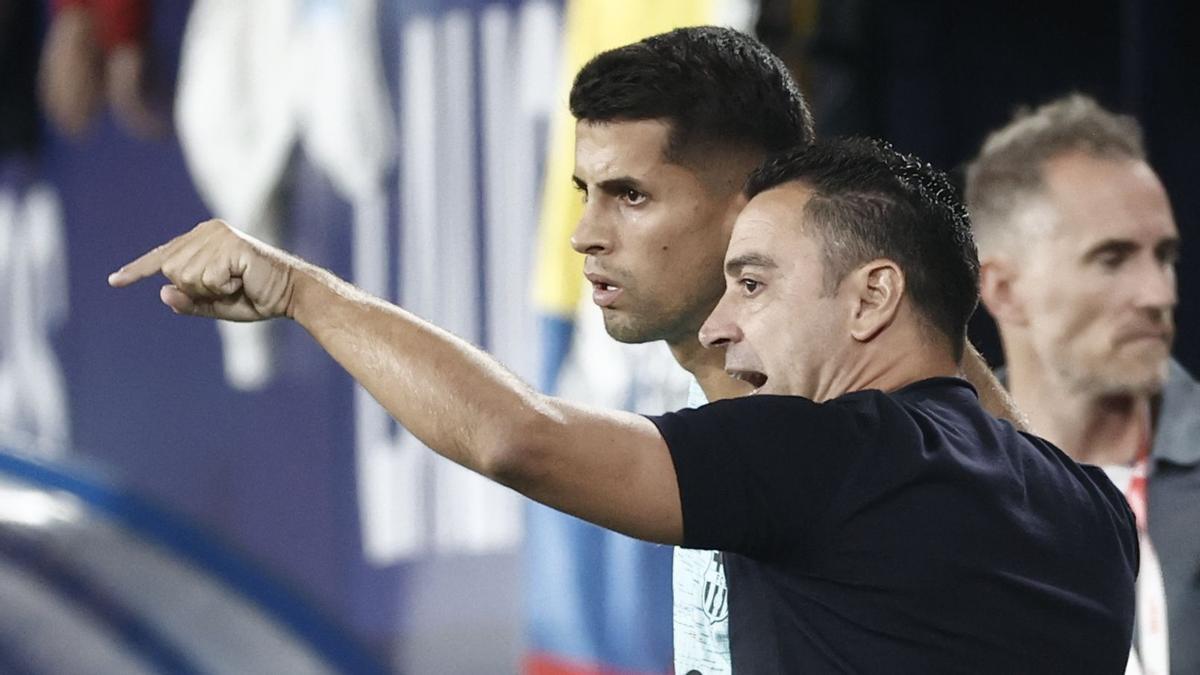 João Cancelo recibe instrucciones de Xavi Hernández antes de entrar al campo.