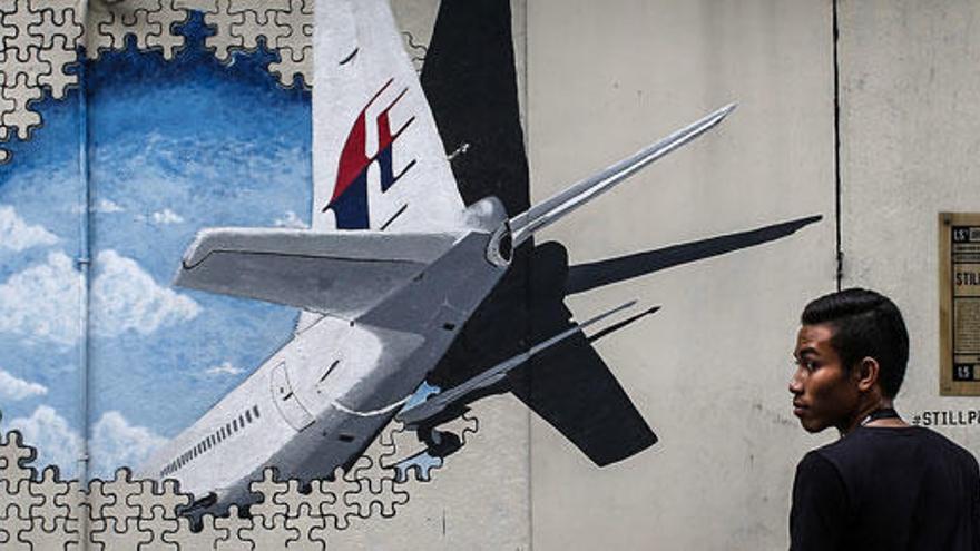 Un joven contempla un mural del avión en Kuala Lumpur.