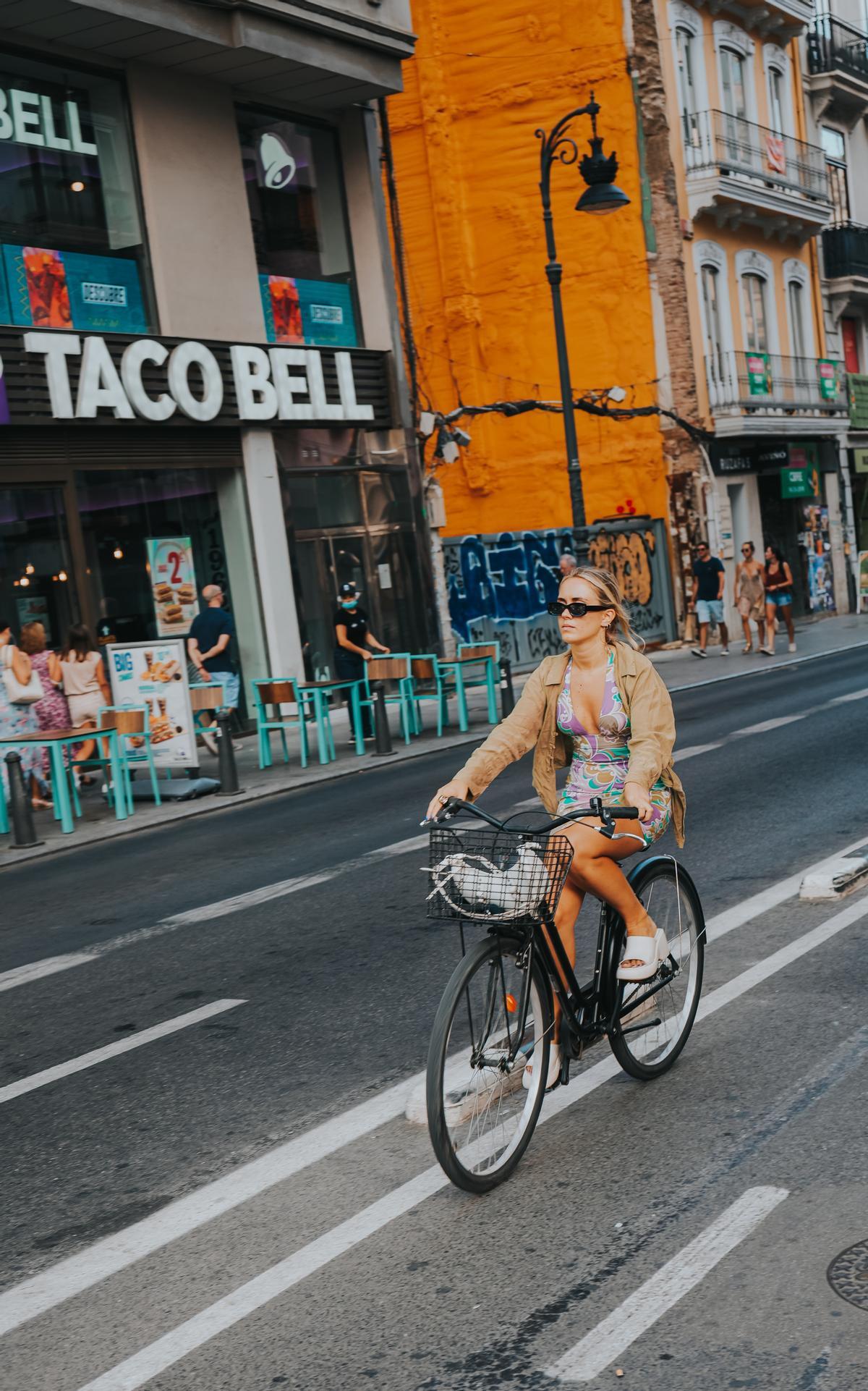 Una ciclista pasa por delante del Taco Bell de la calle Ruzafa