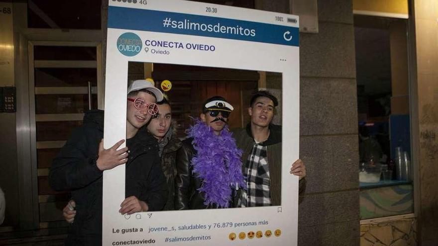 Tres jóvenes, con un voluntario en el centro, ayer, en la calle del Rosal.