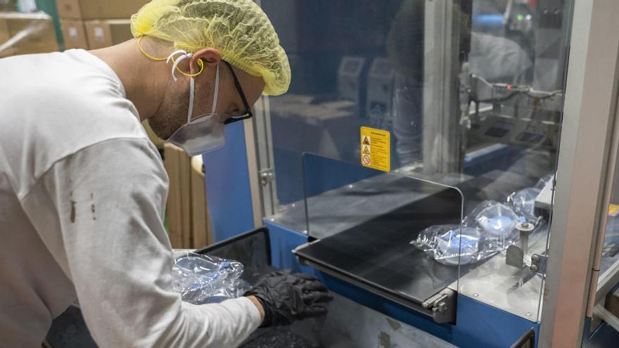 Un trabajador en una empresa que fabrica mascarillas reutilizables.