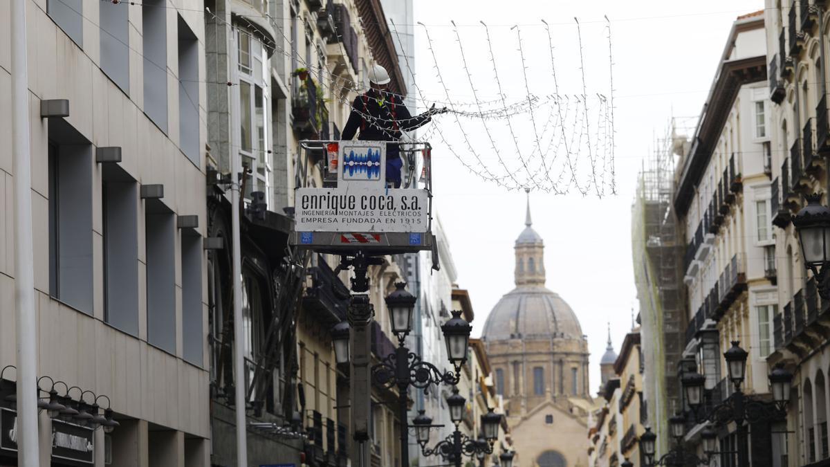 Uno de los operarios trabajando este martes en el montaje de la iluminación navideña en la calle Alfonso de Zaragoza.