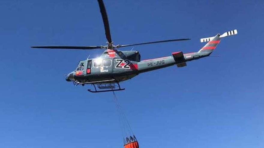 Un helicóptero descarga agua en un incendio en Aliste.