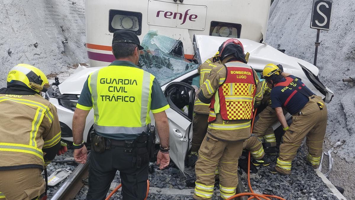 Los efectivos de emergencias junto al coche arrollado por el tren en Lugo.