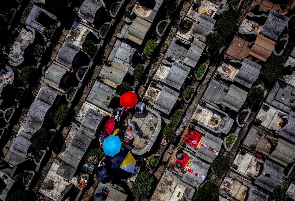 Una fotografía realizada con un dron muestra un cementerio de Cantón durante la celebración del Festival del Quinming, este viernes, en China. En esta festividad anual los familiares visitan y limpian las tumbas de sus seres fallecidos en una atmósfera feliz en la que incluso comen, hacen ejercicio o bailan.