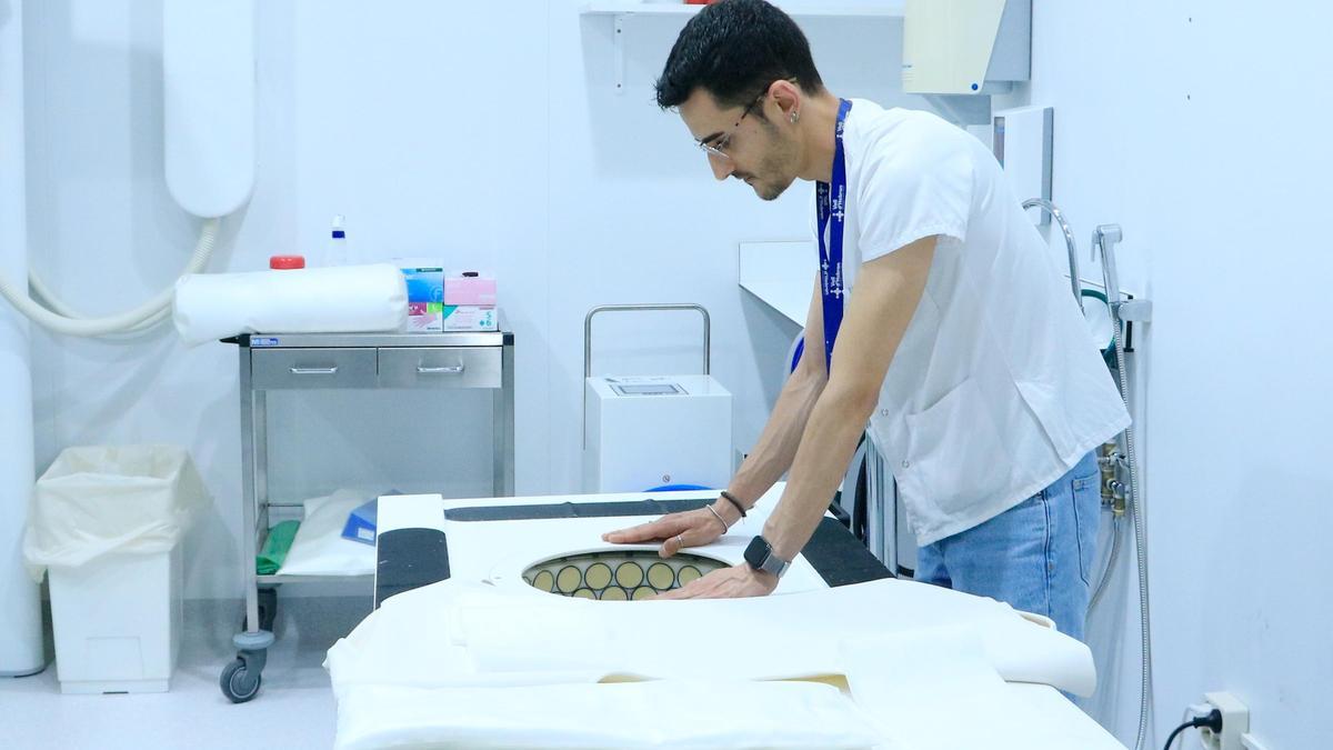 Un colaborador del proyecto europeo QUSTom prepara la cama prototipo de Tomógrafo Informatizado por Ultrasons, aparato que se utiliza para la detección del cáncer de mama, en una prueba de concepto en el Hospital Vall d'Hebron.