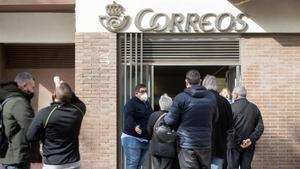 Varias personas hacen cola en una oficina de Correos de Barcelona, ayer, en el último día para admitir peticiones de voto por correo.
