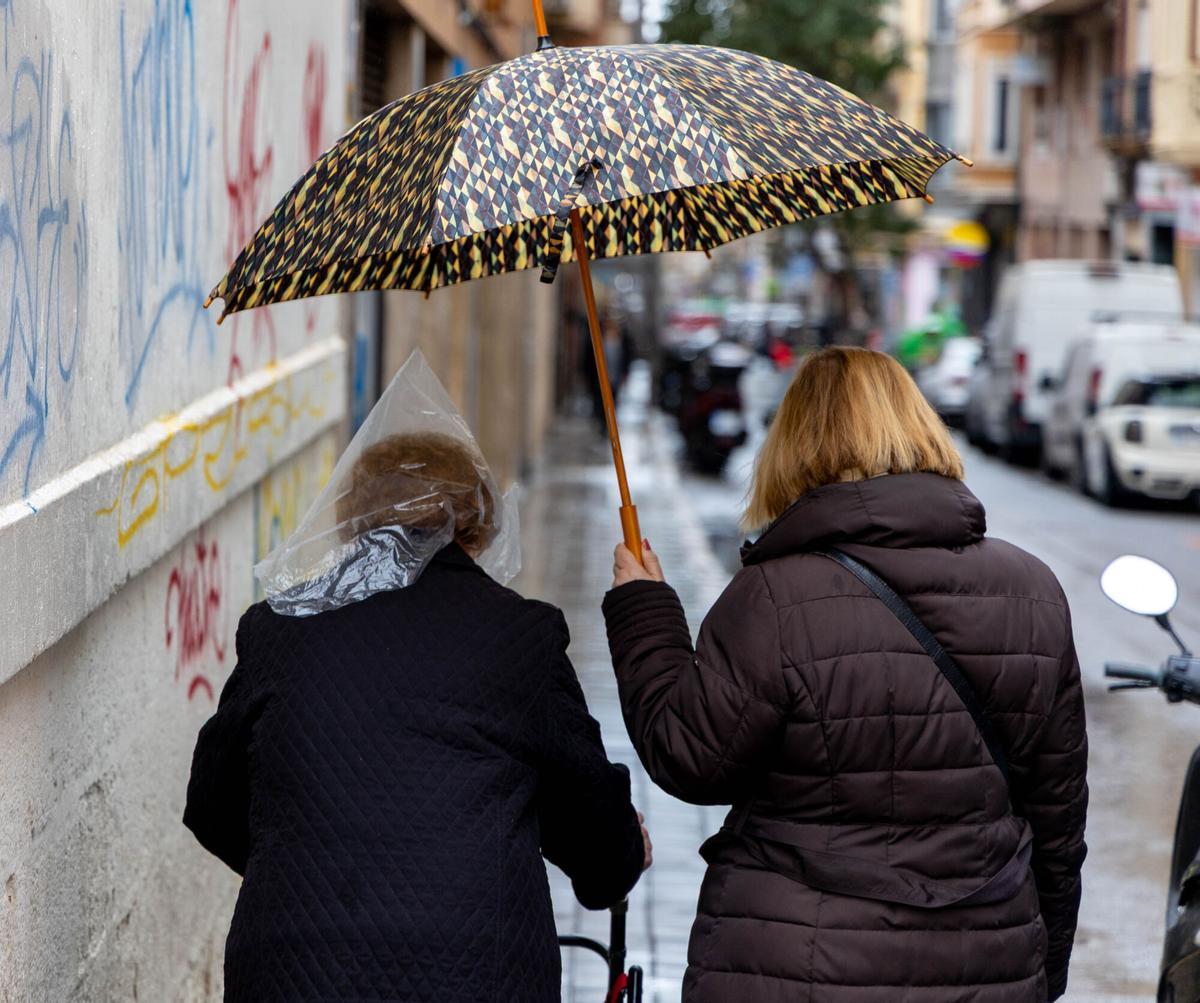 Personas bajo la lluvia en Alicante.