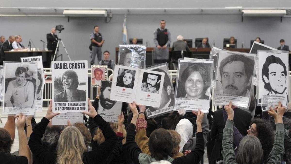 Un grupo de personas sostienen retratos de sus familiares desaparecidos durante el juicio al último presidente de la dictadura argentina, Reynaldo Bignone, el 20 de abril del 2010.