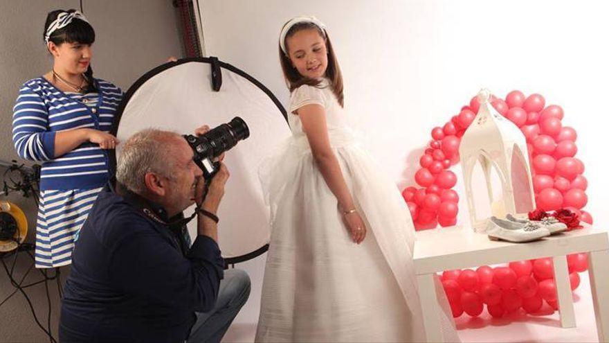 Una niña vestida de comunión posa para una sesión fotográfica.