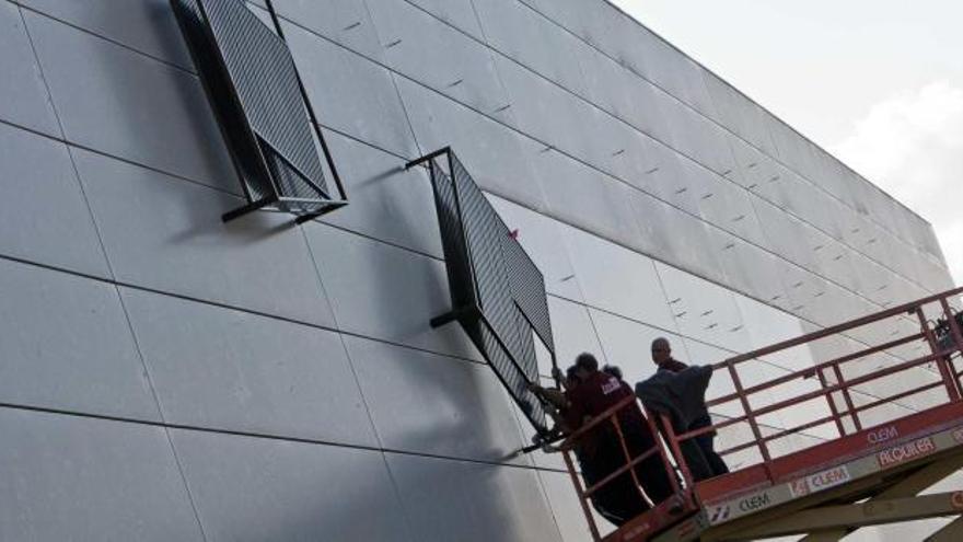 Los operarios instalan las primeras piezas del mural de Eusebio Sempere en la fachada de la antigua terminal del aeropuerto de El Altet, en una imagen tomada ayer.