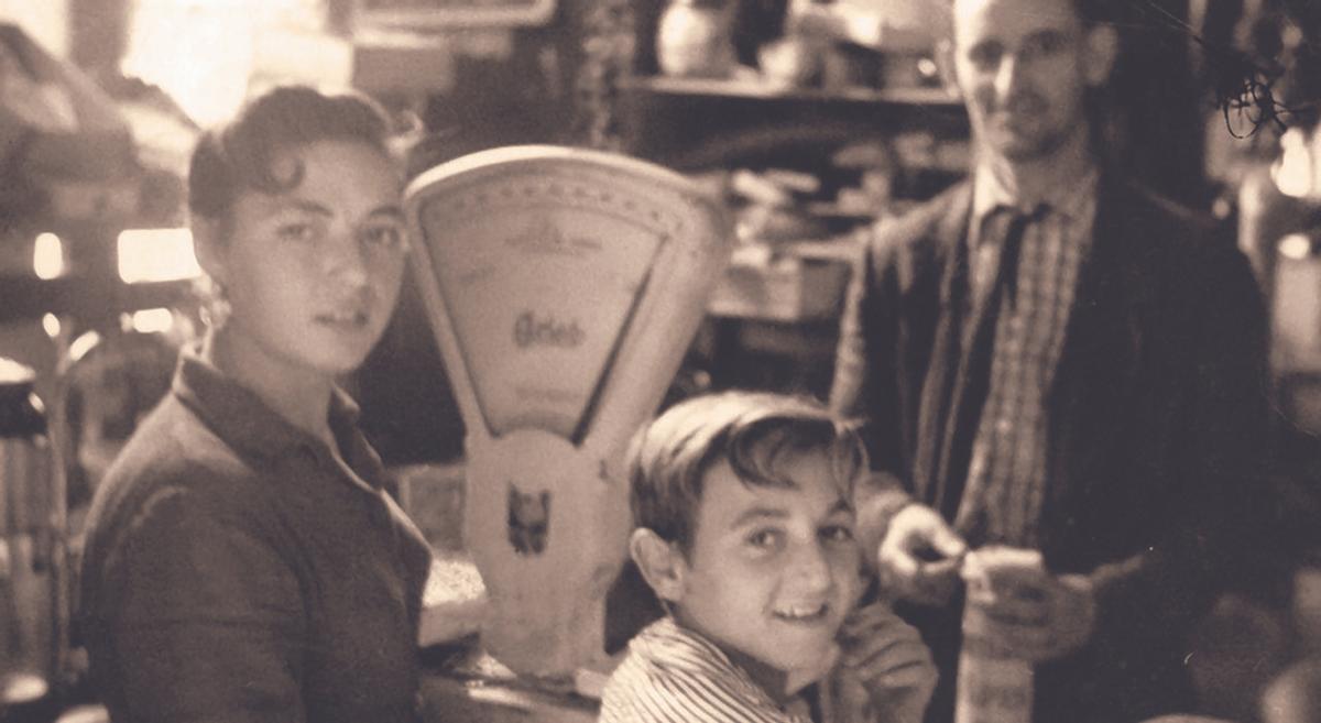 Su padre con unos clientes en la tienda familiar del Haza de la Alcazaba.