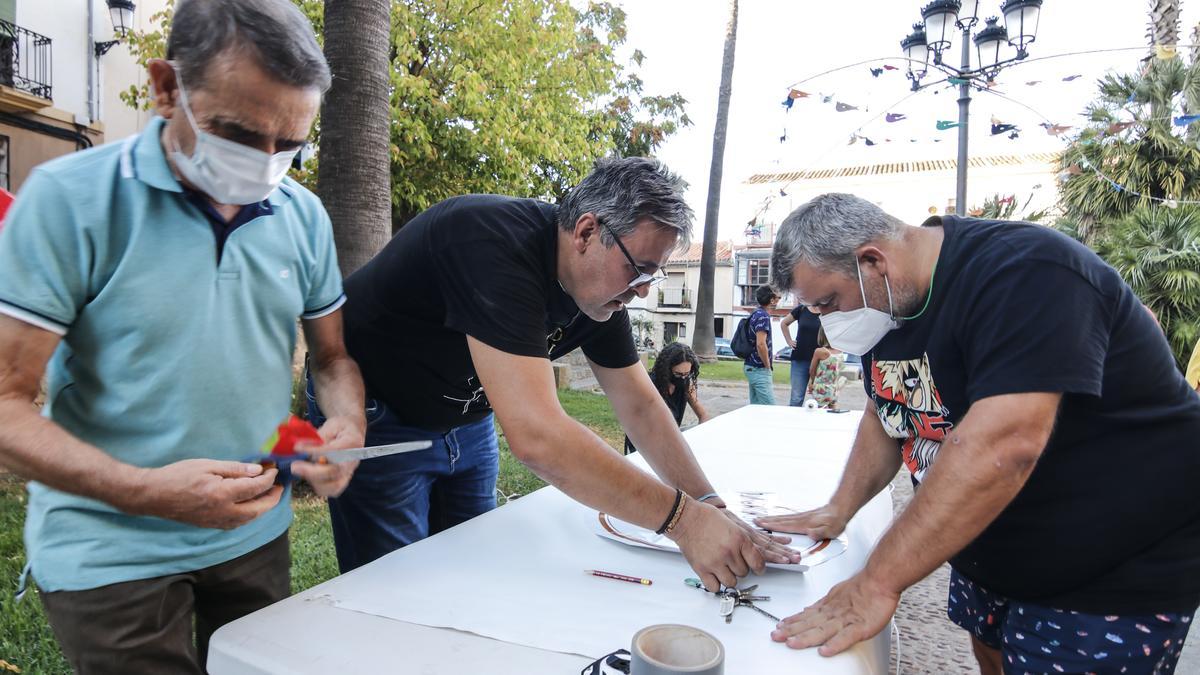 Los vecinos confeccionando el material para engalanar la plaza.