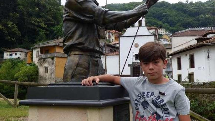 Aritz Asturiano Losas junto a la escultura del tirador, con la capilla del Carmen al fondo.