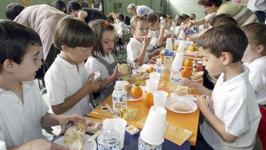 Varios niños toman el almuerzo durante el servicio de comedor.