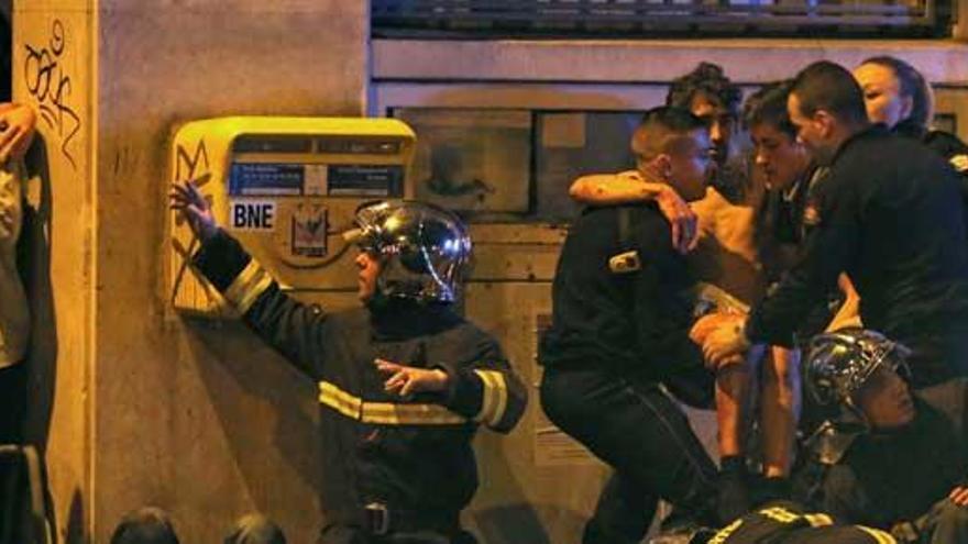Un grupo de personas atienden a un herido de Bataclan.