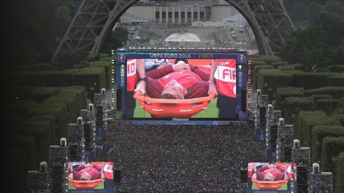 Miles de aficionados observan en las pantallas gigantes, junto a la Torre Eiffel, la lesión de Cristiano.