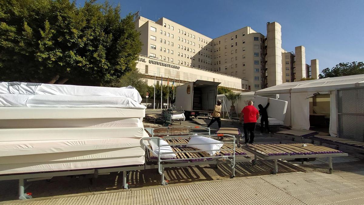 Een groep arbeiders haalt bedden en matrassen weg uit het veldhospitaal in Alicante. | JOSE NAVARRO