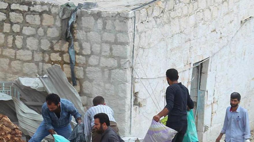 Civiles sirios rebuscan entre ruinas en Alepo tras un ataque aéreo ruso.