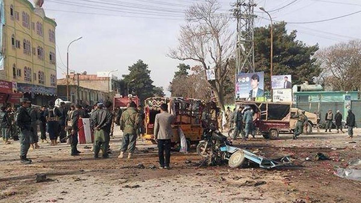 Transeúntes y militares afganos inspeccionan la escena del ataque suicida, este martes en Maymana.