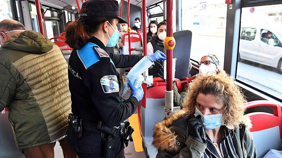 Reparto de mascarillas en un autobús en A Coruña.