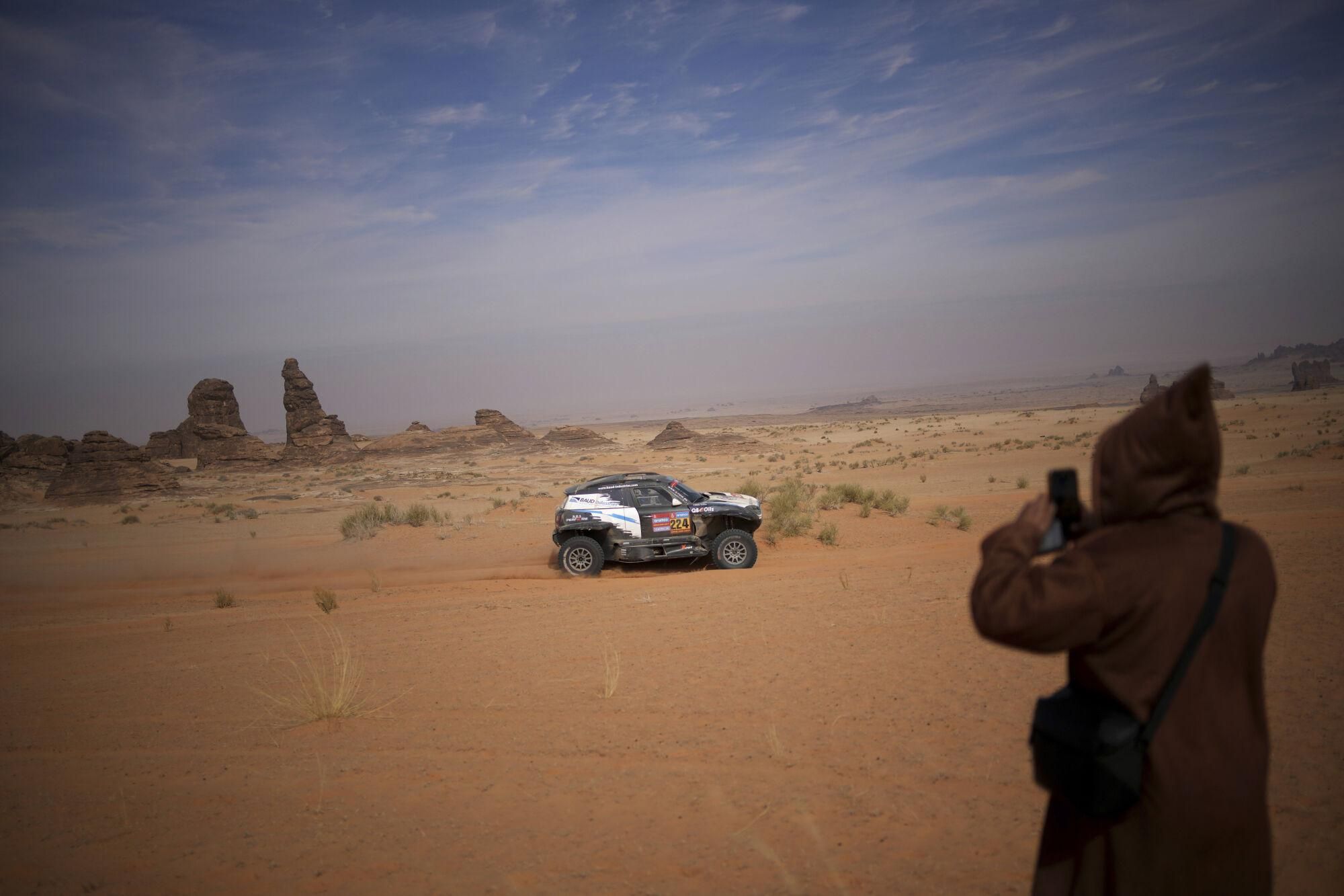 A man takes a photo of Driver Lionel Baud and co-driver Lucie Baud during the fifth stage of the Dakar Rally between Alula and Hail, Saudi Arabia, Thursday, Jan. 9, 2025. (AP Photo/Christophe Ena). EDITORIAL USE ONLY / ONLY ITALY AND SPAIN