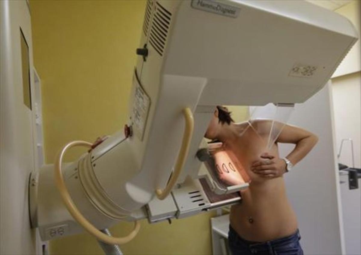 Una dona se sotmet a una mamografia per radiografiar-li l’estat del pit.