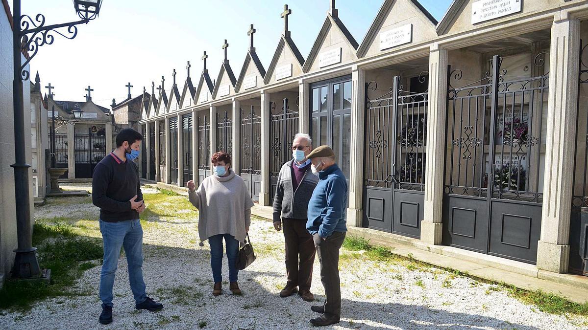 Samuel Lago, a la izquierda, conversa con tres de los vecinos que promueven el arreglo del cementerio. |   // NOÉ PARGA