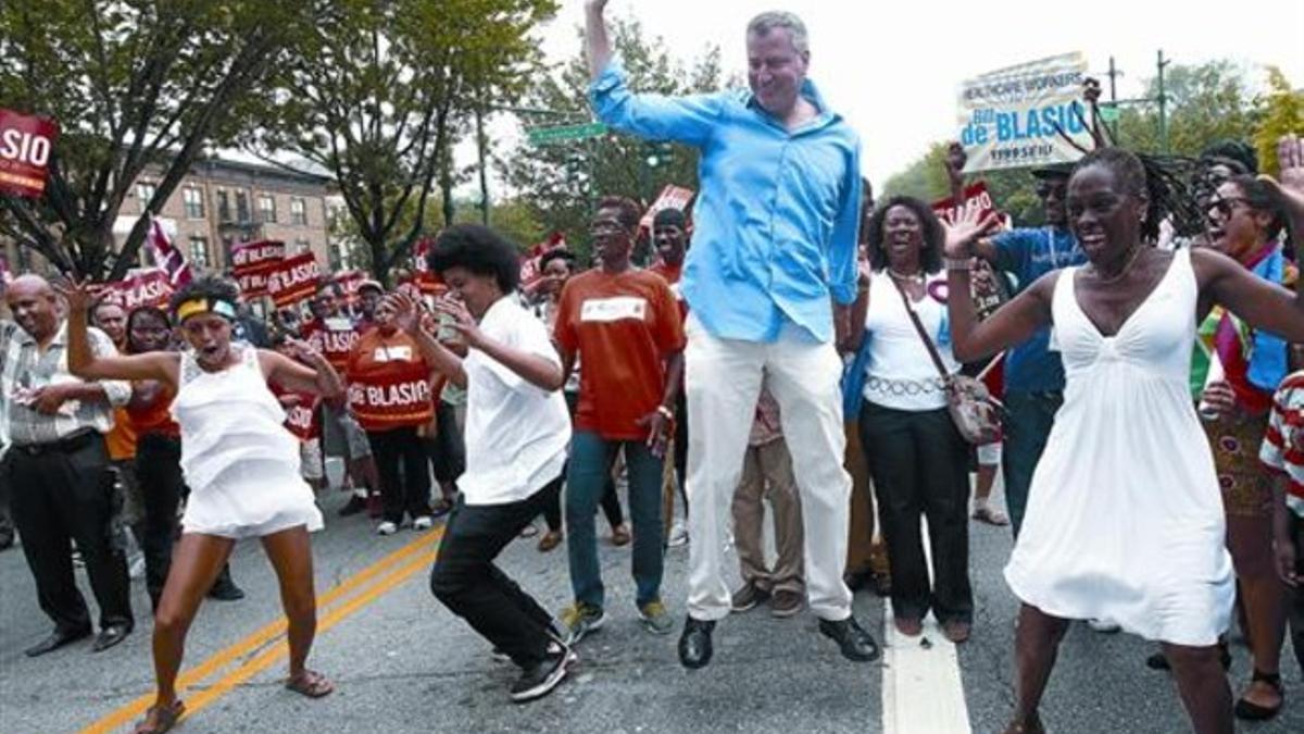 En el aire, Bill de Blasio, favorito en las primarias demócratas del martes a la alcaldía de Nueva York. A la derecha, su esposa, Chirlane McCray; a la izquierda, sus hijos Chiara y Dante.