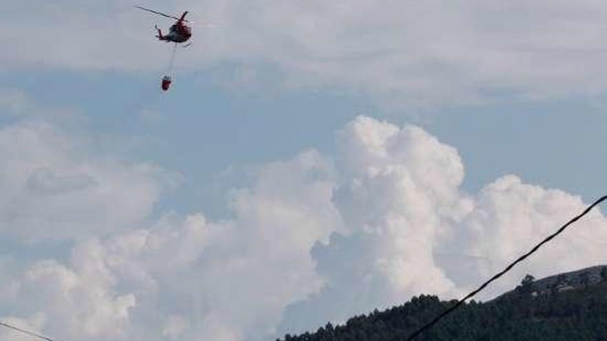 Un helicóptero trabajando en la extinción. // J. Lores