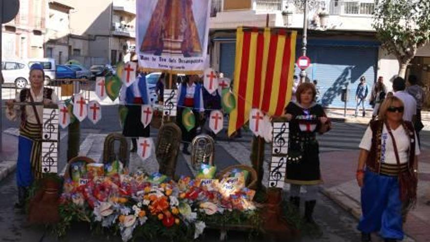 A la izquierda, jóvenes festeros portan flores para la Mare de Déu. A la derecha, los cargos festeros durante la Ofrenda.