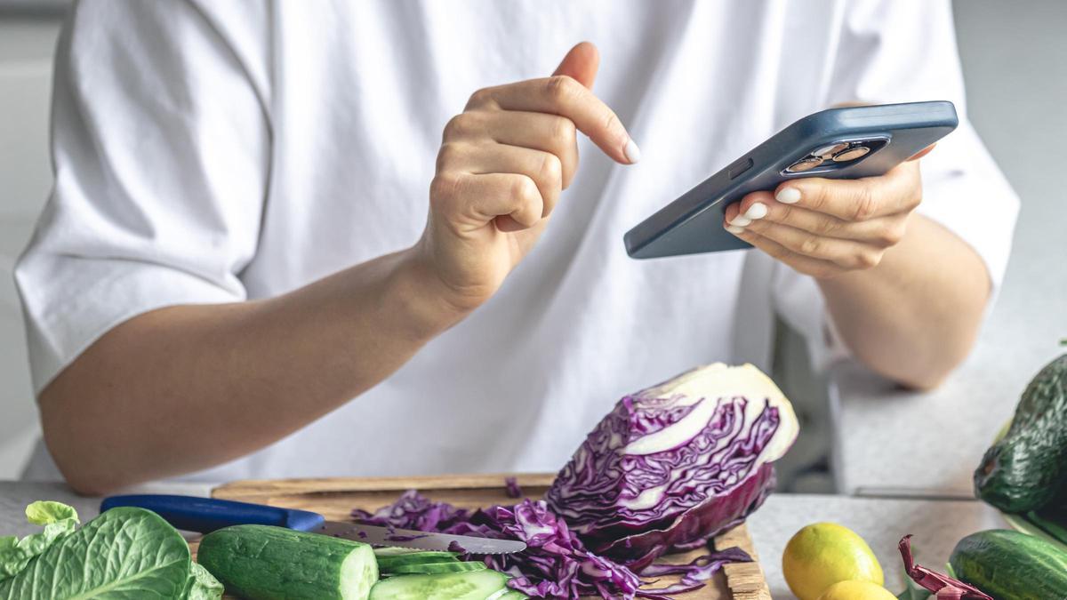 Una dona fa una cerca sobre alimentació al seu telèfon mòbil, en una imatge d'arxiu.