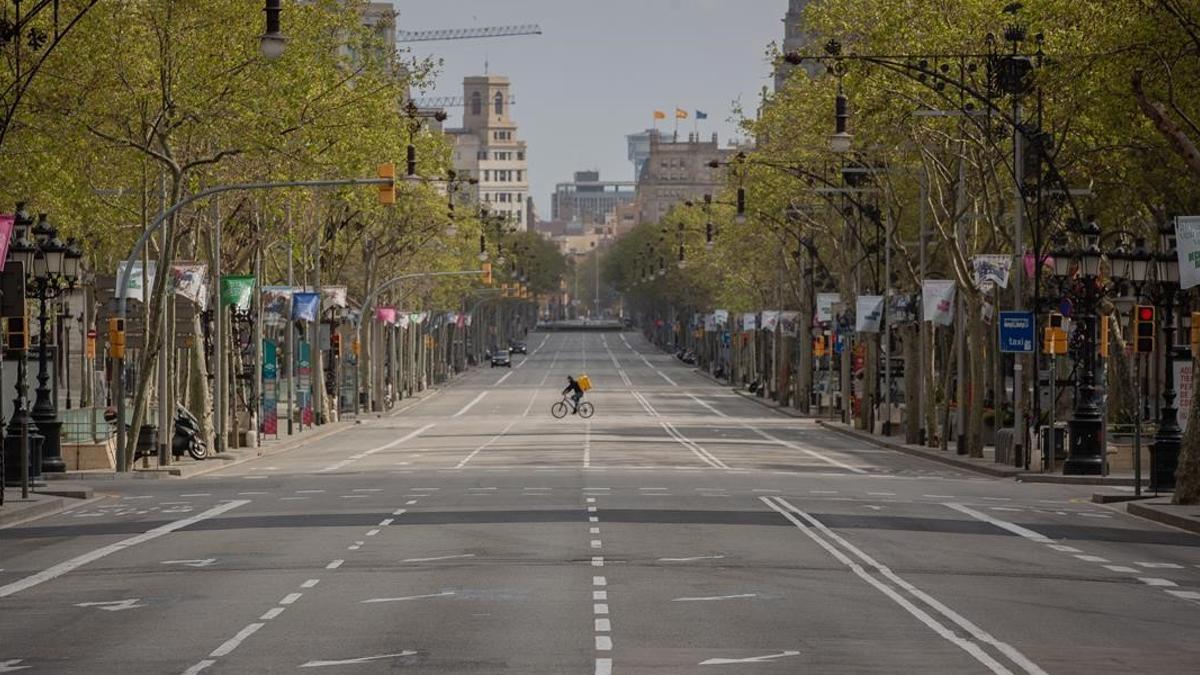 Un trabajador de Glovo en bicicleta por el Paseo de Gracia  vacio durante el primer dia laborable de la segunda semana desde que se decreto el estado de alarma en el pais a consecuencia del coronavirus  en Barcelona Catalunya (Espana) a 23 de marzo de 2020   23 MARZO 2020 COVID-19 PANDEMIA ENFERMEDAD  David Zorrakino   Europa Press  23 03 2020