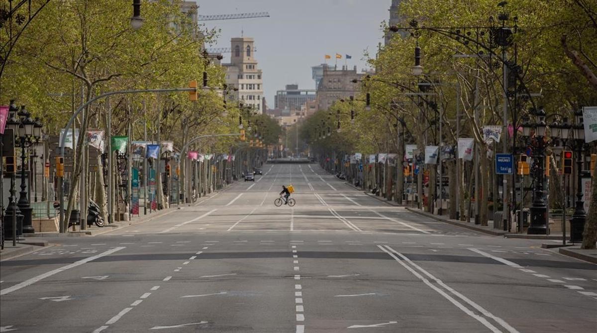 Un trabajador de Glovo en bicicleta por el Paseo de Gracia  vacio durante el primer dia laborable de la segunda semana desde que se decreto el estado de alarma en el pais a consecuencia del coronavirus  en Barcelona Catalunya (Espana) a 23 de marzo de 2020   23 MARZO 2020 COVID-19 PANDEMIA ENFERMEDAD  David Zorrakino   Europa Press  23 03 2020