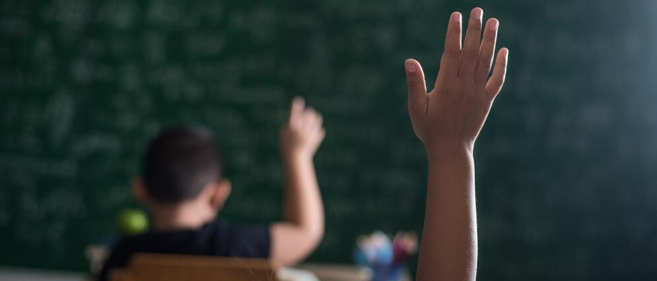 kid raising his hand in classroom