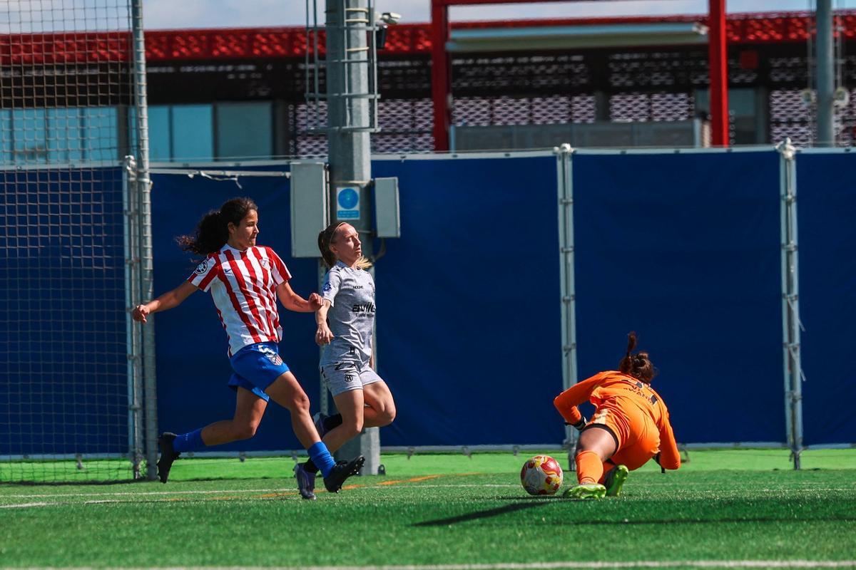 Elena Pradilla trata de hacerse con el balón ante dos futbolistas del Atlético de Madrid C