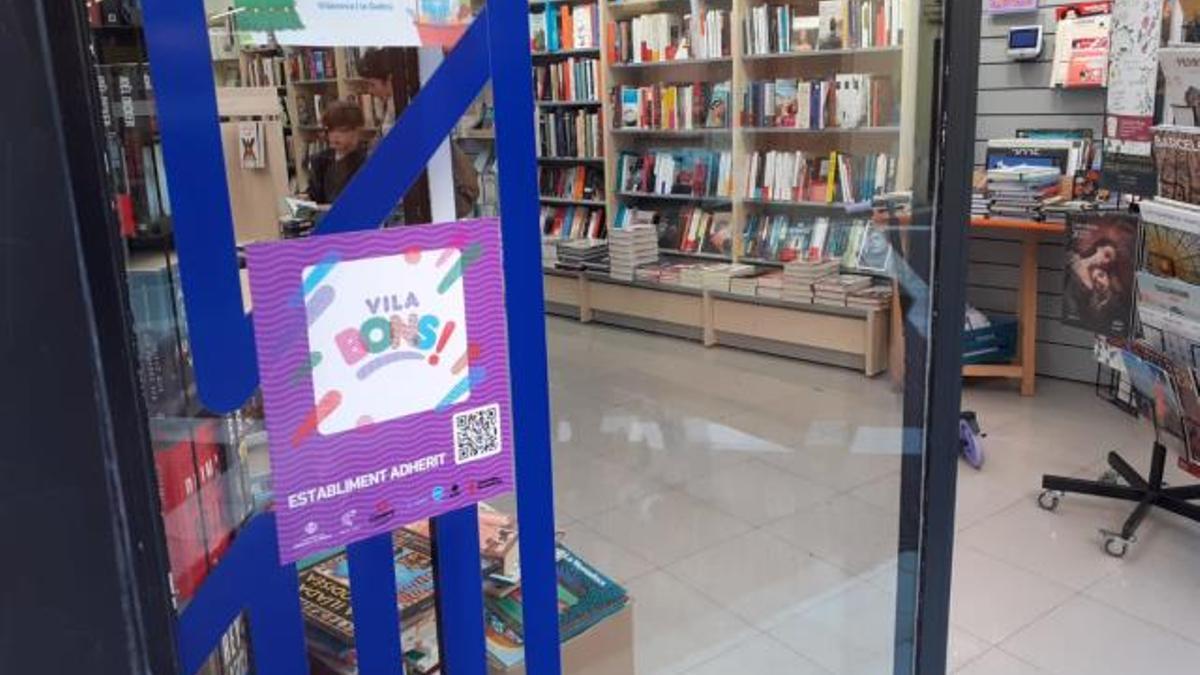 Escaparate de una librería de Vilanova con la pegatina de establecimiento adherido a la campaña de los Vilabons