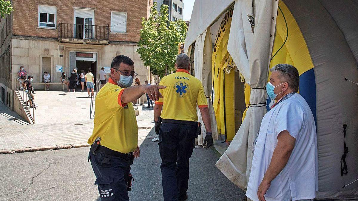 Personal de emergencias junto a los albergues y pabelllones instalados para alojar a los temporeros y tratar de evitar la propagación del rebrote de coronavirus en Torres de Segre, Lleida.