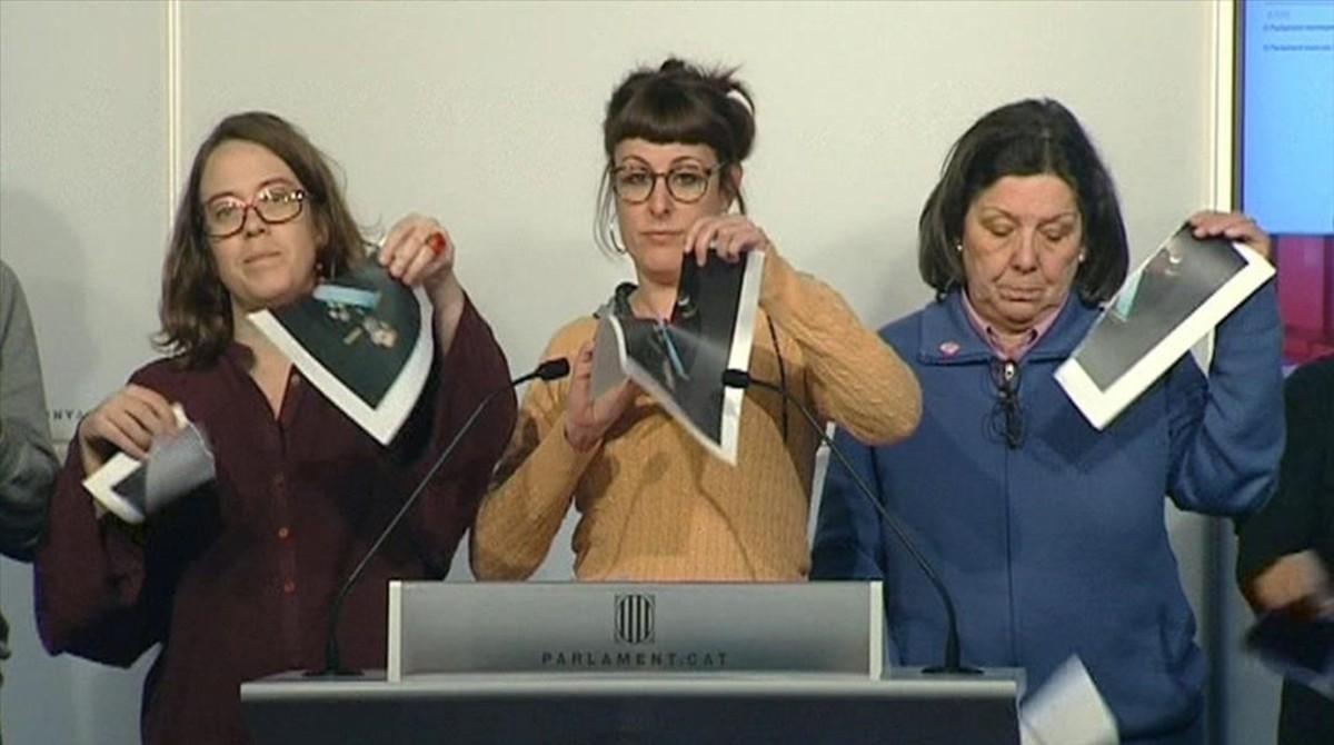 Las diputadas de la CUP Eulàlia Reguant, Mireia Vehí y Gabriela Serra rompen fotos del Rey en una rueda de prensa en el Parlament.