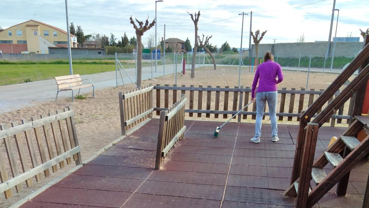 Una madre barre una zona del parque infantil del parque de Antona García