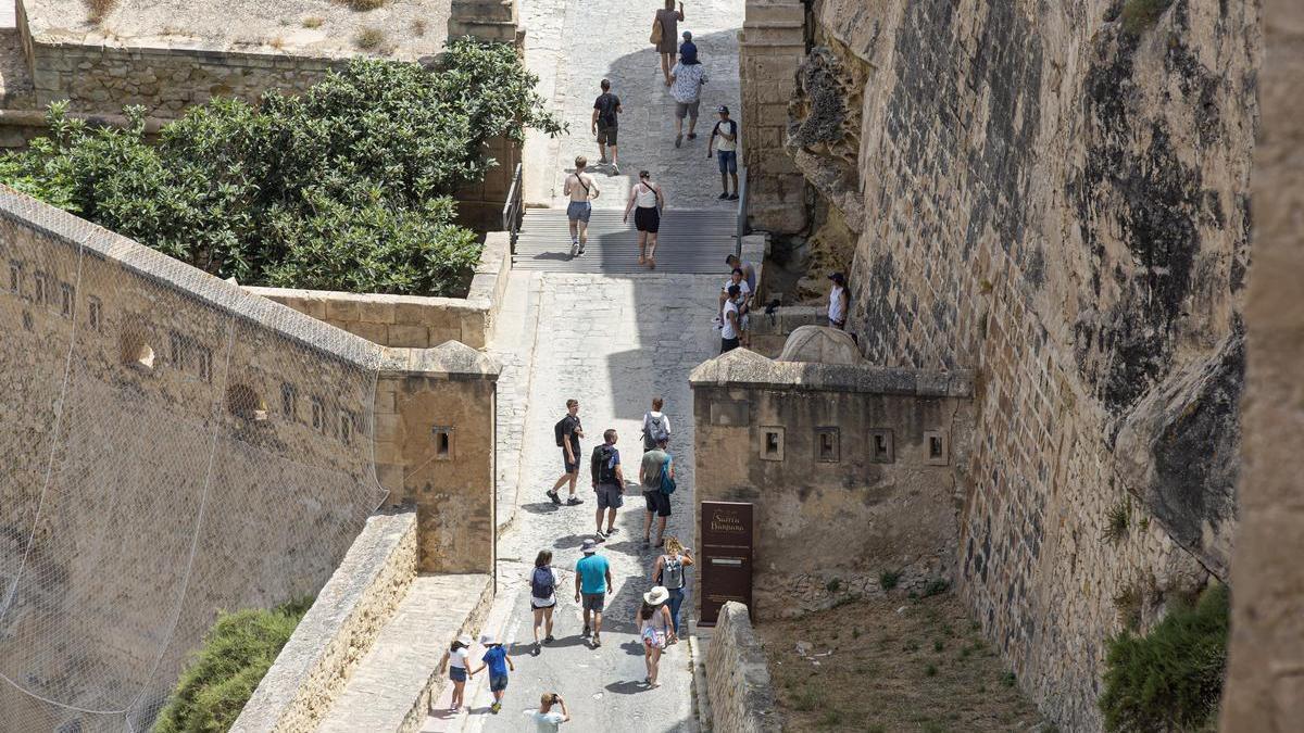 Turistas llegan a pie al castillo de Santa Bárbara, este verano, pese a la existencia de lanzadera y ascensor
