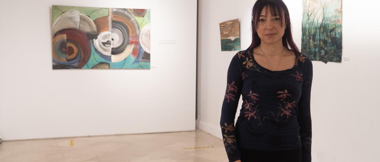 Carmen Ratón junto a varias de sus obras expuestas en la Alhóndiga