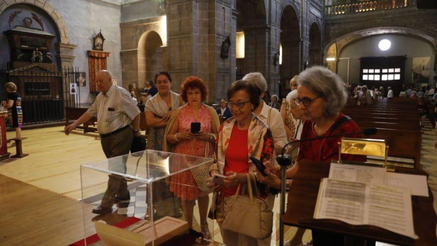 Varios fieles ante el ladrillo de la puerta santa de la basílica papal. | FERNANDO RODRÍGUEZ