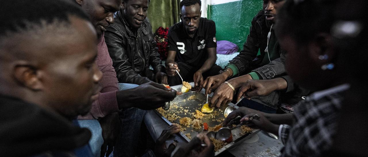 Inmigrantes africanos comparten un arroz en una vivienda del Besòs, en Barcelona.
