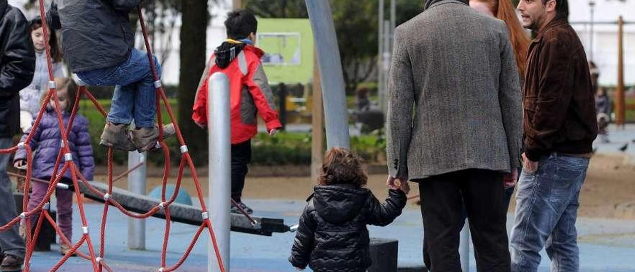 Niños con sus padres en un parque infantil de la ciudad. // G. Santos