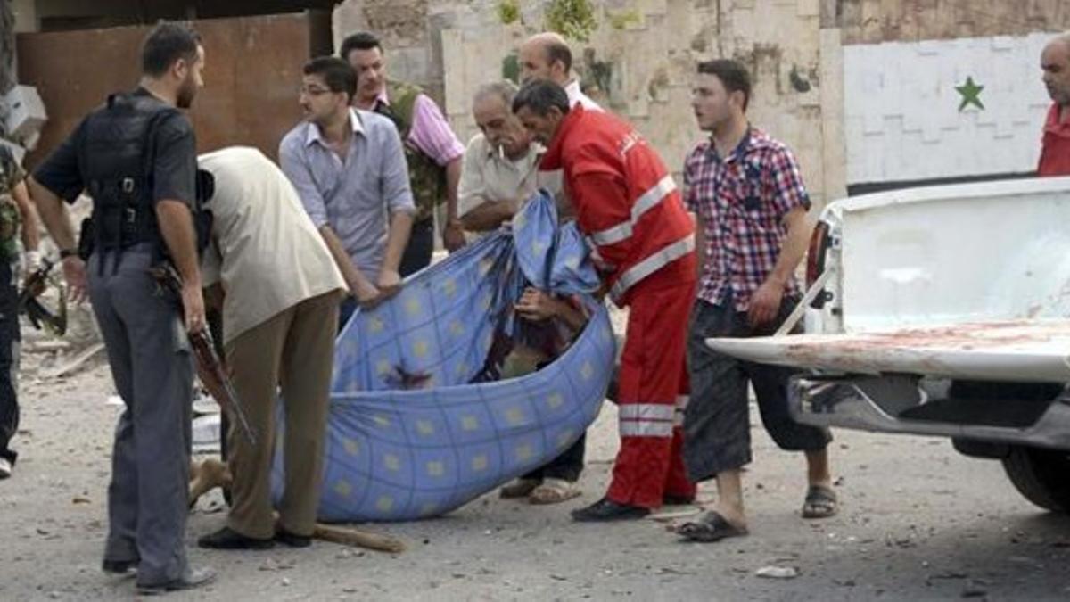 Unos hombres recogen el cadáver de una de las víctimas de los atentados