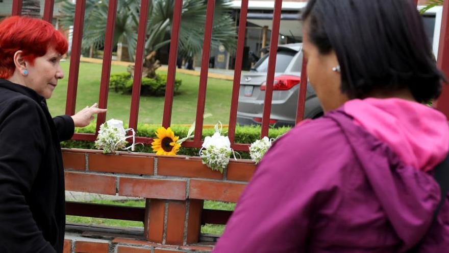 Dos mujeres homenajean al capitán Acosta con flores.